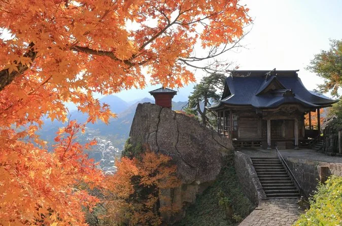 Yamadera temple buildings on a forested hillside in autumn colour