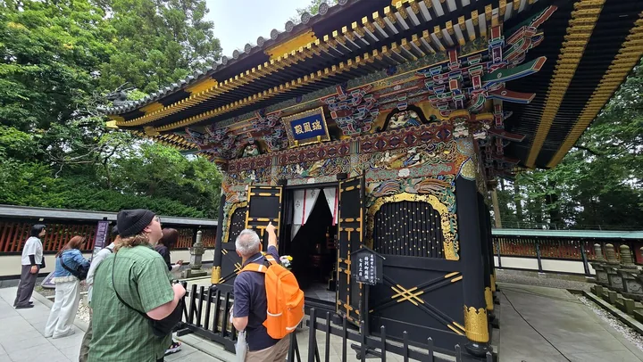 Visitors walking up to the ornate gate of the Zuihoden mausoleum