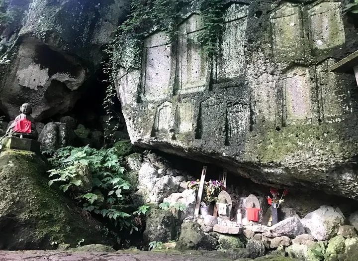 Rock face with carved niches holding small stone statues
